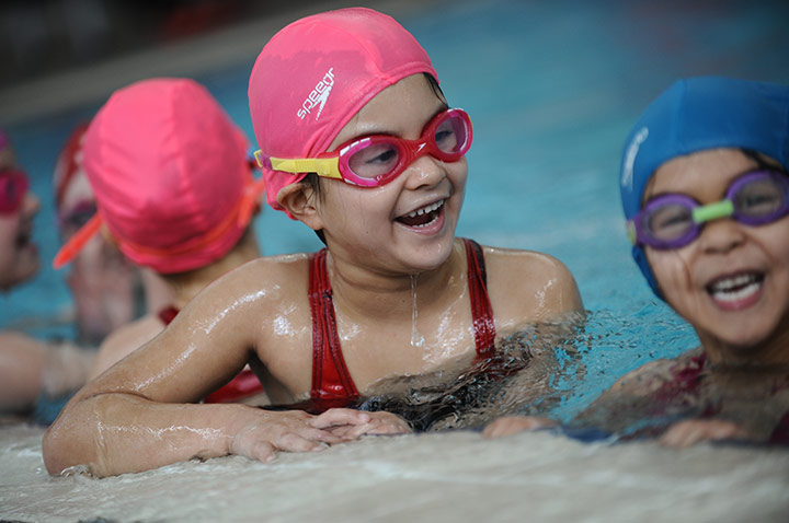Young students smiling in a swimming pool